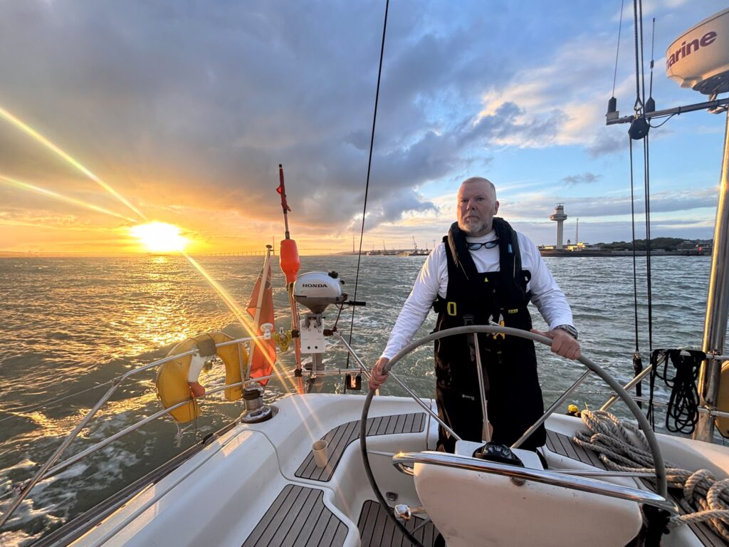 Crew helming on around Britain sailing adventure